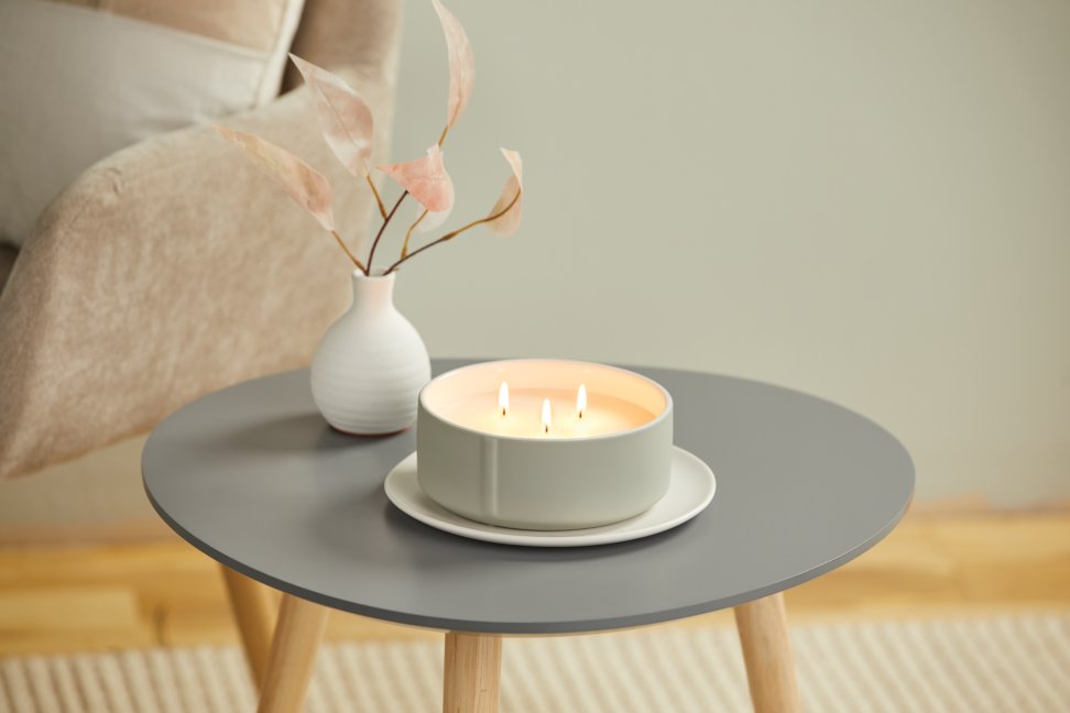 three wick minimalist candle on gray side table