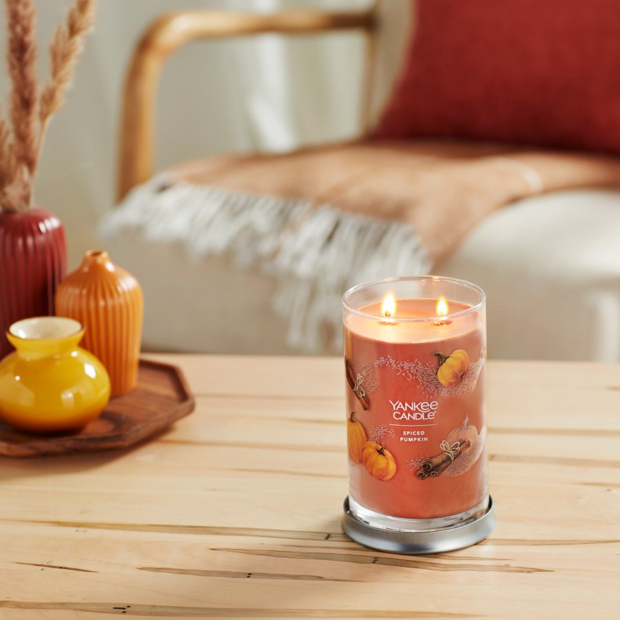 Spiced Pumpkin tumbler candle on table with vases