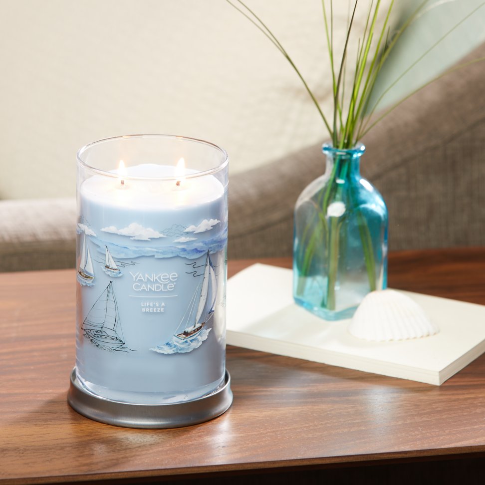life's a breeze signature large tumbler candle on table in living room