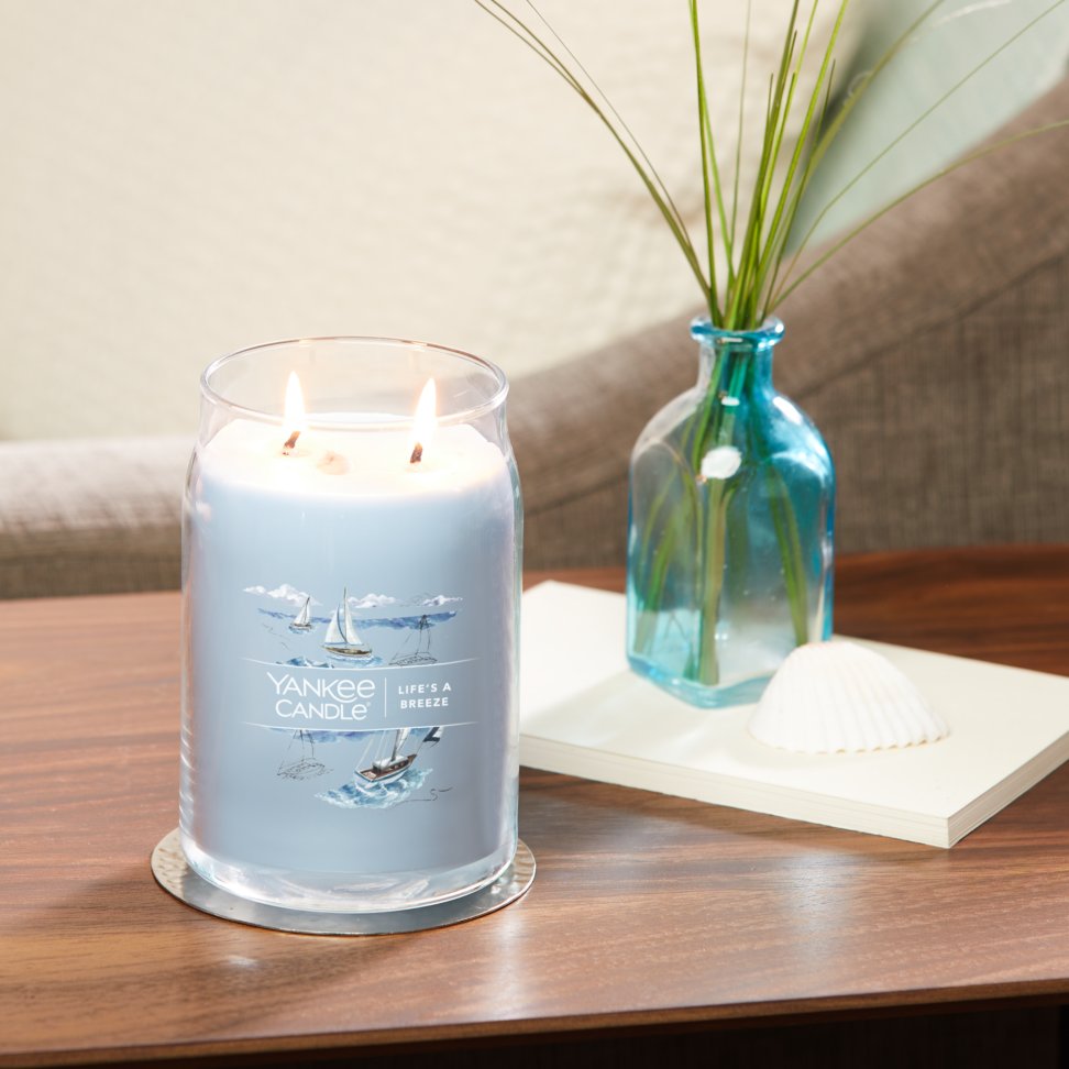 life's a breeze signature large jar candle on table in living room