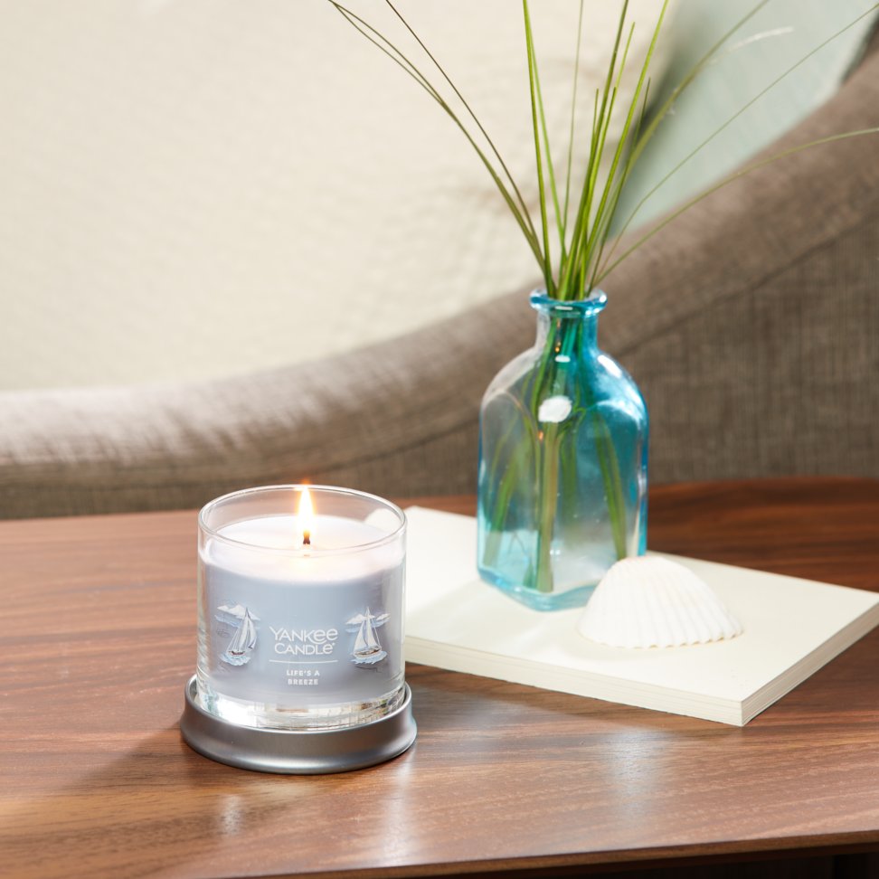 life's a breeze signature small tumbler candle on table in living room