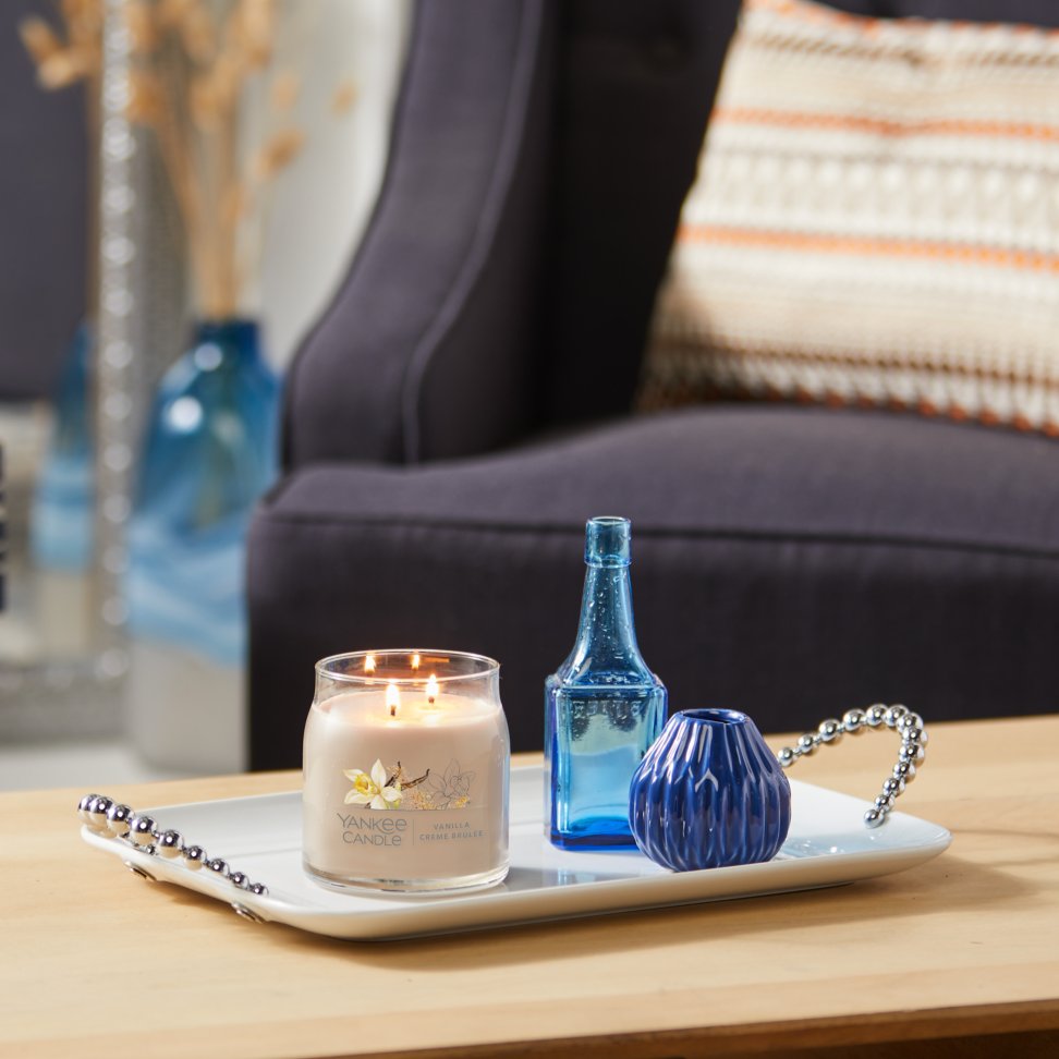 vanilla creme brulee signature medium jar candle with two vases on coffee table