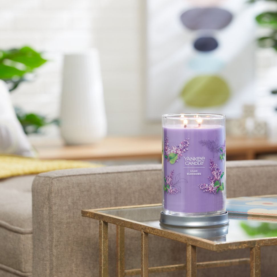 lilac blossoms signature large tumbler candle lit on side table