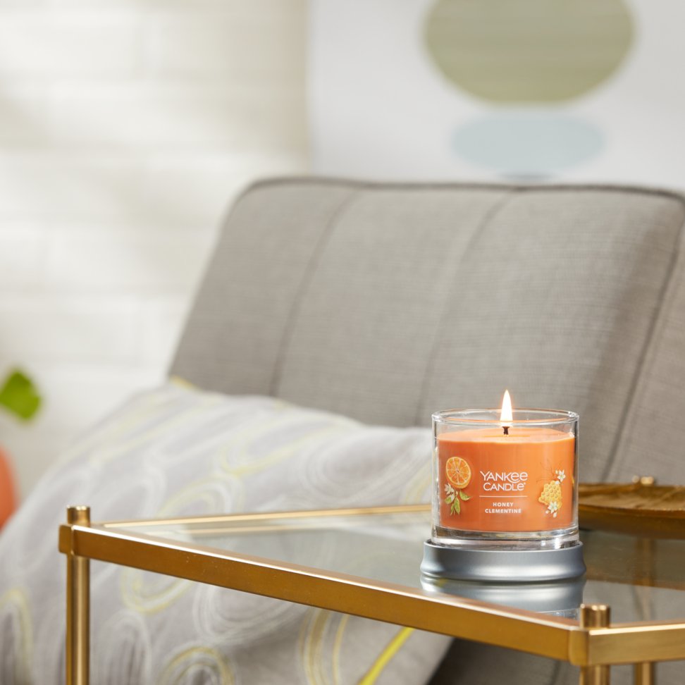 honey clementine signature small tumbler candle lit on side table