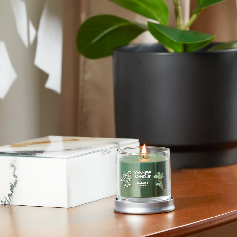 balsam and cedar signature small tumbler candle lit on side table