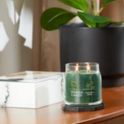 balsam and cedar signature medium jar candle lit on side table image number 3
