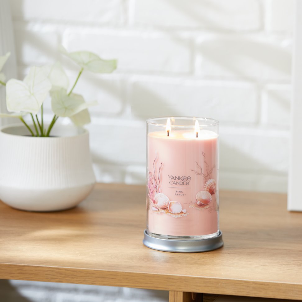 pink sands signature large tumbler candle lit on side table