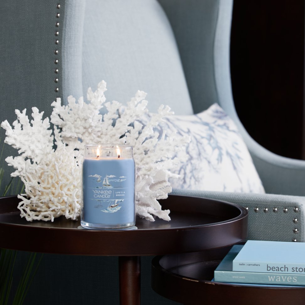 life's a breeze signature large jar candle on table in living room