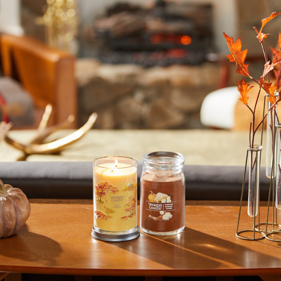 sunlit autumn signature large tumbler candle and pumpkin banana scone signature large jar candle on table