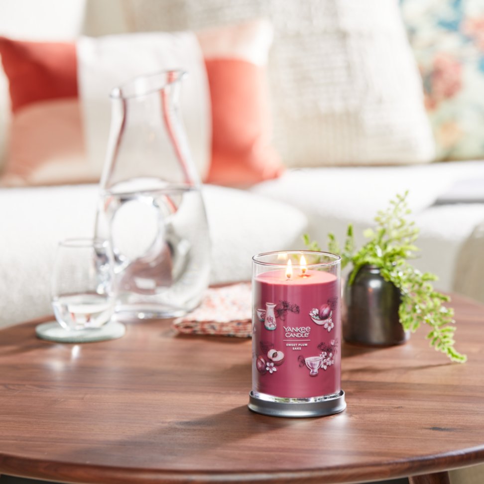 sweet plum sake signature large jar candle on living room table