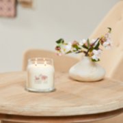 sakura blossom festival signature medium jar candle on table image number 6