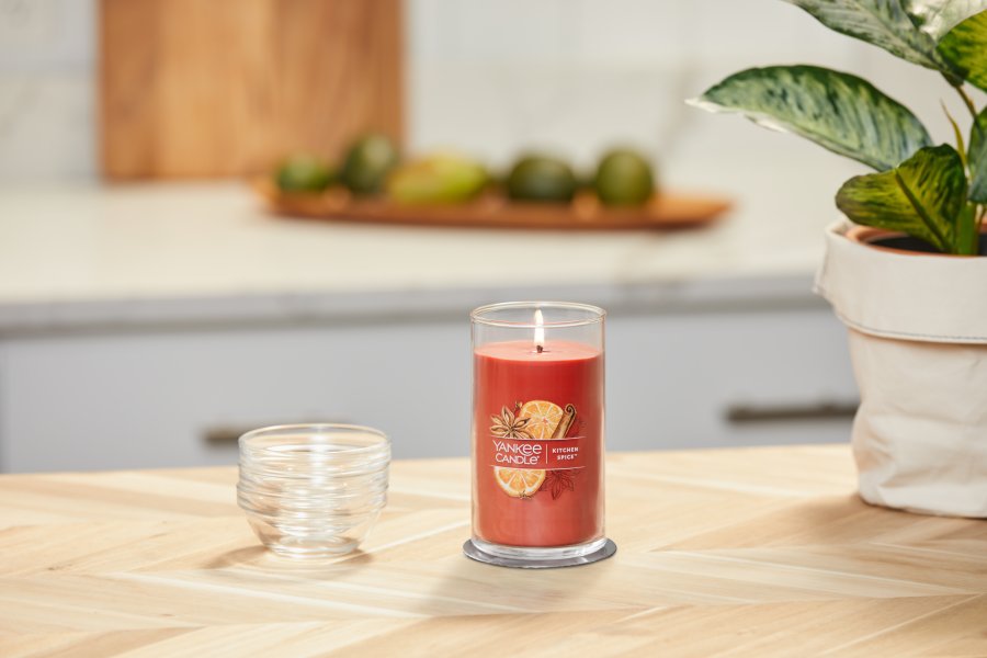 lit kitchen spice signature medium pillar candle on wooden counter