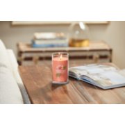 lit tropical breeze signature medium pillar candle on wooden table next to open book image number 4
