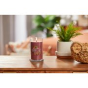 lit home sweet home signature medium pillar candle on wooden table next to a potted plant and basket image number 3