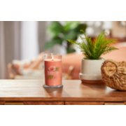 lit tropical breeze signature medium pillar candle on wooden table next to a potted plant and basket image number 3