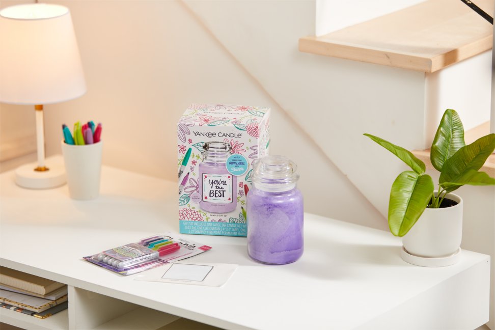 a create your own one-of-a-kind personalized candle label and a purple-colored original large jar candle next to a pack of cosmic colored sharpies on a white table