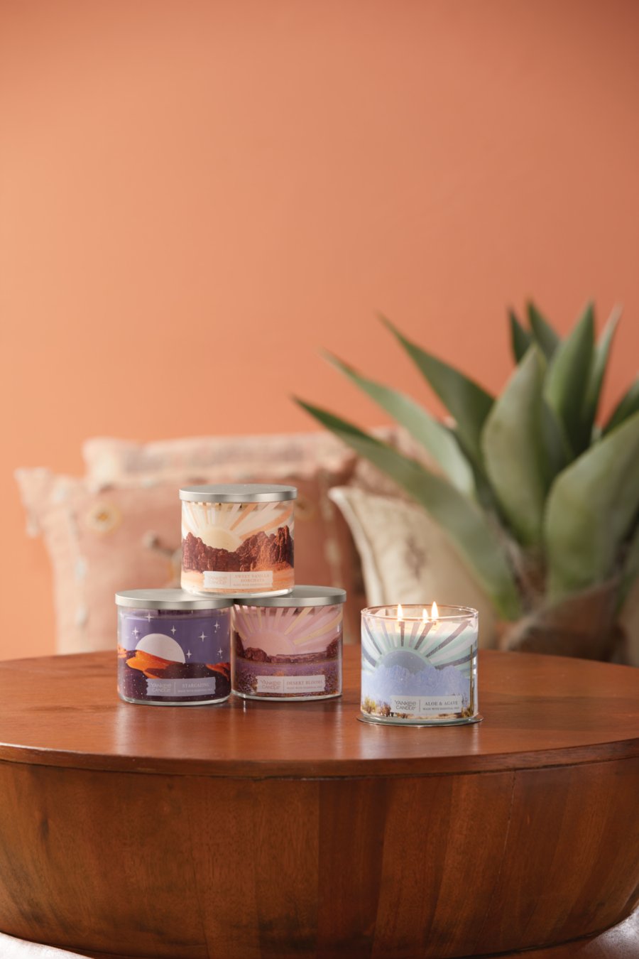 the under the desert sun collection featuring a stargazing 3-Wick candle, a sweet vanilla horchata 3-Wick candle, a desert blooms 3-Wick candle, and an aloe & agave 3-Wick candle on a wood table