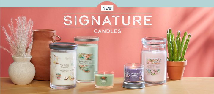 new signature candles signage featuring a sweet vanilla horchata signature large tumbler candle, an aloe & agave signature medium pillar candle, a canyon pine trail yankee candle minis, a stargazing signature small tumbler candle, and a desert blooms signature large jar candle on a table