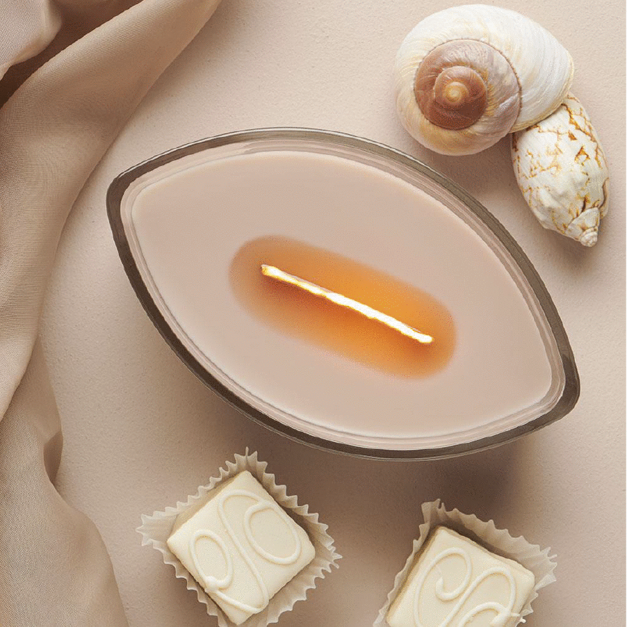 teardrop candle next to chocolates and seashells