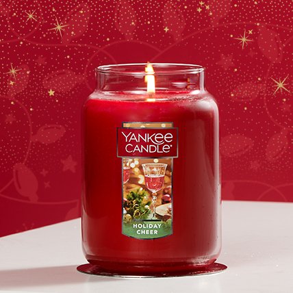 holiday cheer original large jar candle lit on red background