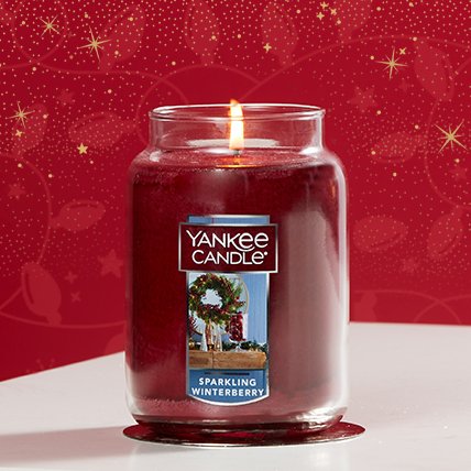 lit sparkling winterberry original large jar candle with red holiday background