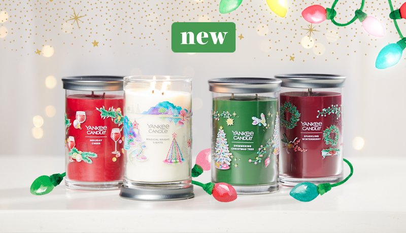 new four signature large tumbler candles in festive fragrances with gold sparkles and colored lights