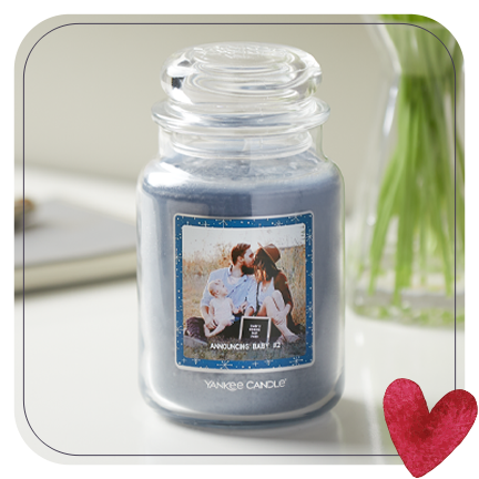 an original large jar candle with a new baby announcement personalized photo label on a table