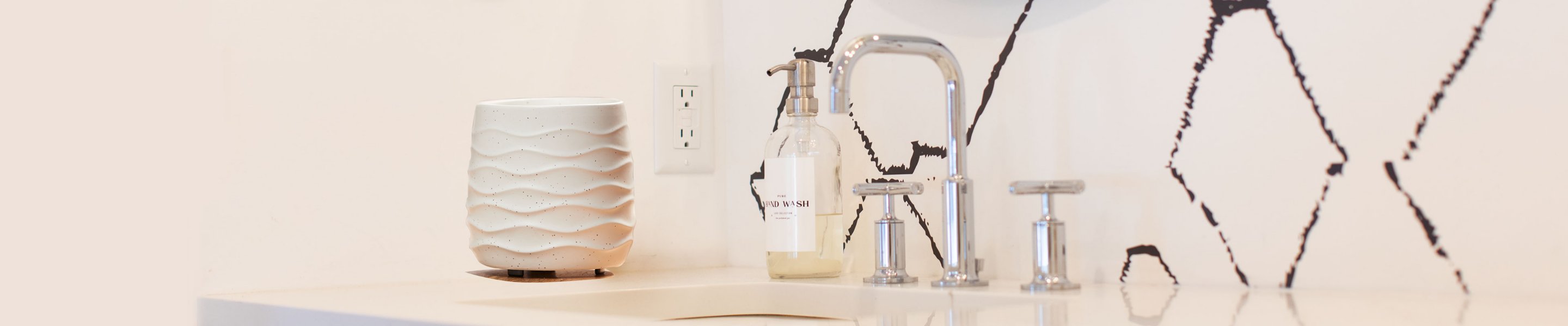 white patterned wax warmer on bathroom sink with bottle of soap and faucet