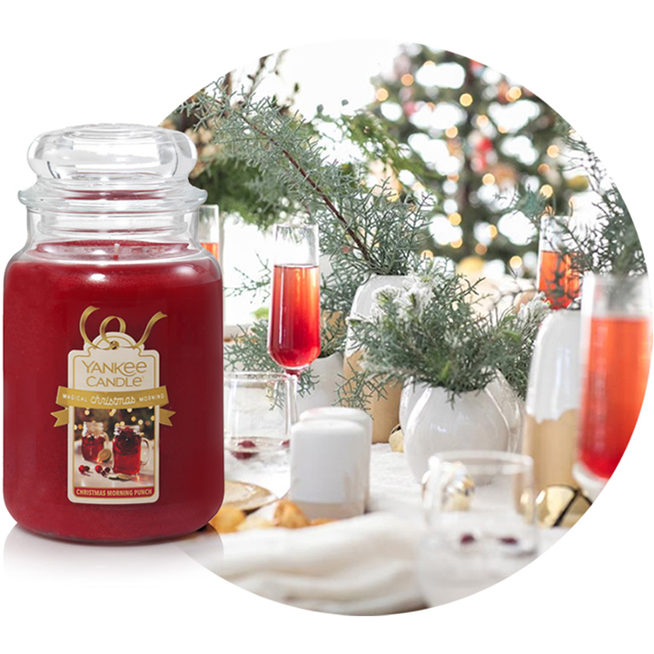 christmas morning punch scented candle next to holiday themed drinks